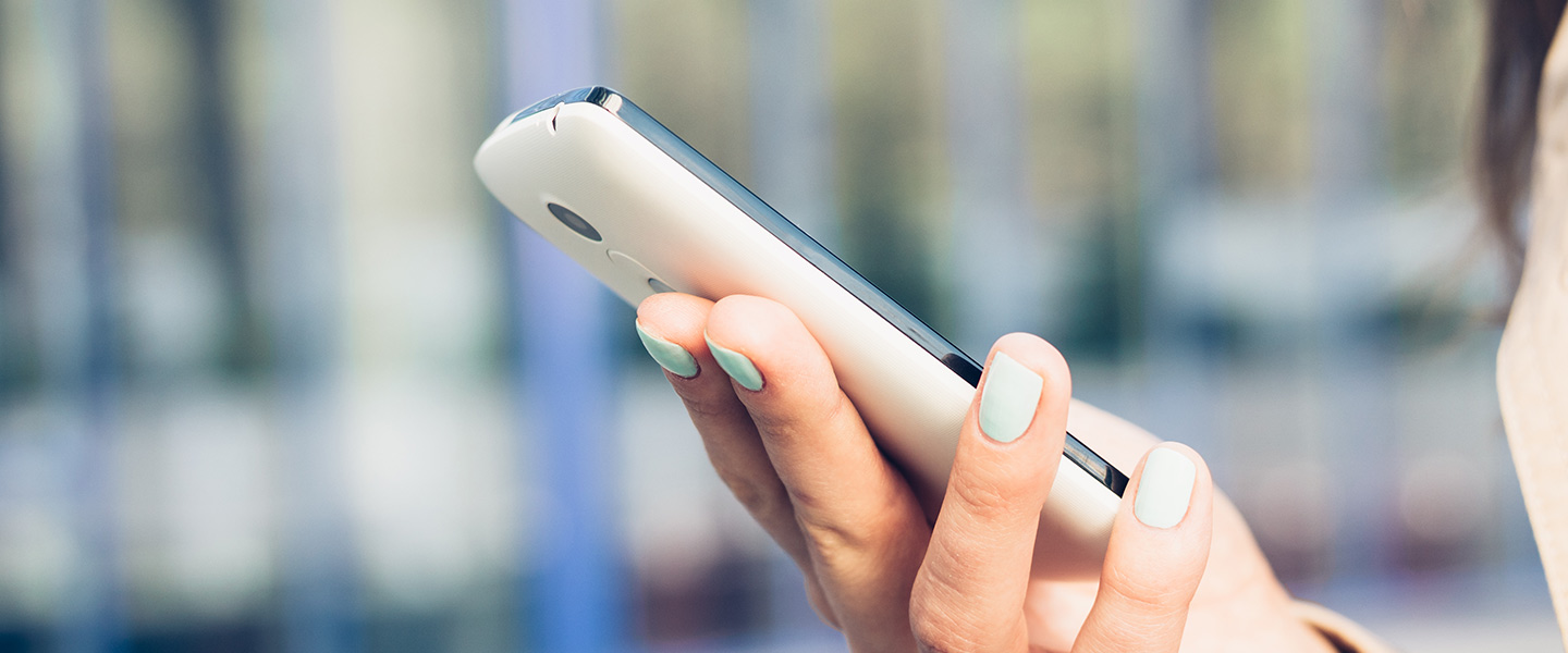 woman's hand holding a cell phone to view a mobile ticket