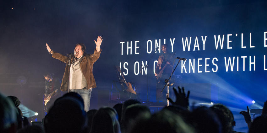 Lead singer of Casting Crown sings with arms raised up to the crowd at BJC in 2017.