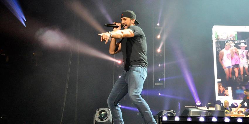 Luke Bryan singing on stage pointing to the crowd at BJC