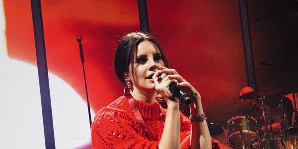 Lana Del Rey sits on stage singing during her performance at BJC