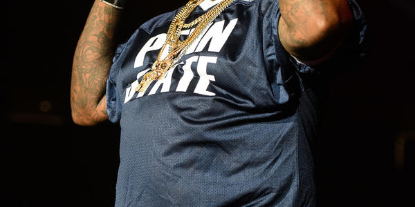 Rick Ross, wearing PSU football jersey and shades, raps for the audience at the Bryce Jordan Center in 2012